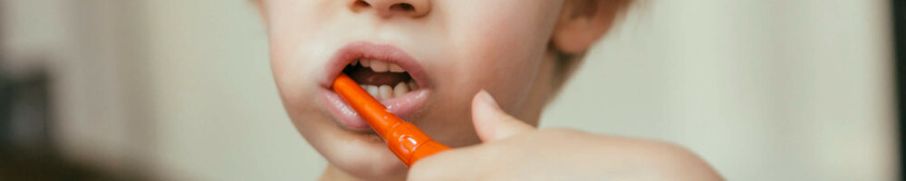 Portrait of little boy brushing his teeth with an electric toothbrush